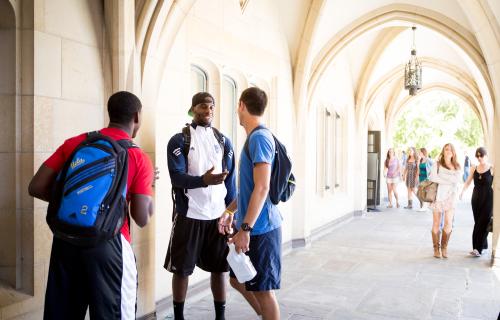 Students linger in the shade of Kerckhoff Hall's Gothic arches.