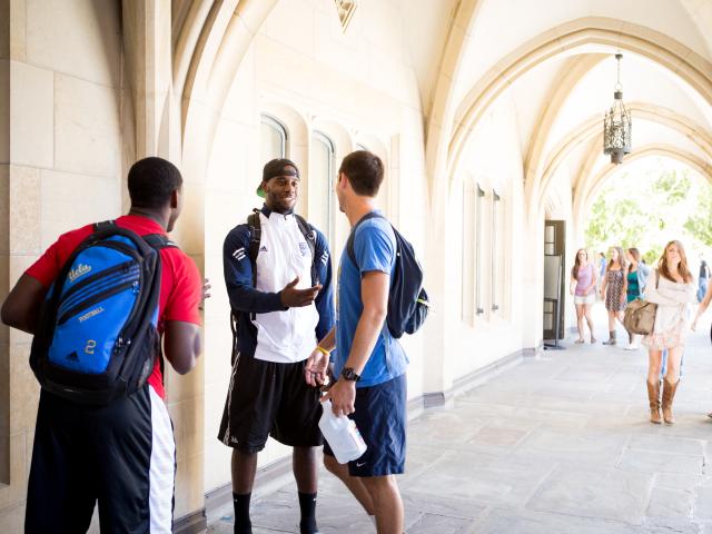 Students linger in the shade of Kerckhoff Hall's Gothic arches.