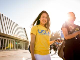o	Two students pause on Bruin Walk near the north entrance to Pauley Pavilion. The student at left wears a UCLA Volunteer Center shirt.
